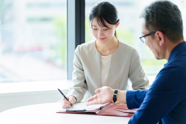 女性が保険書類にサインしている